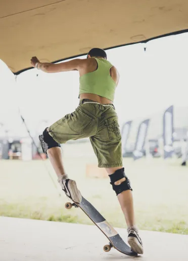 Une personne faisant une figure de skateboard sous une tente de festival