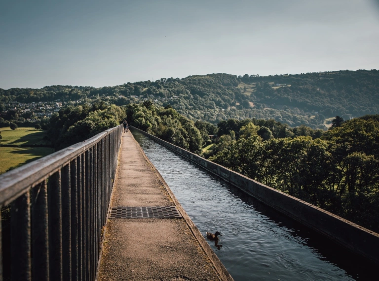 Un aqueduc étroit situé au-dessus d'un paysage verdoyant.