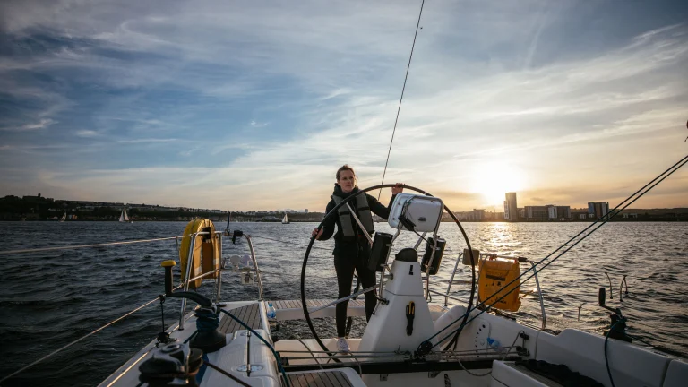 Hannah Mills, à la barre de son voilier, navigue dans la Baie de Cardiff.