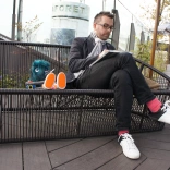 Un homme assis sur un banc en train de dessiner.